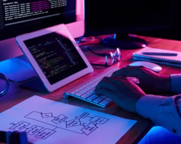 table with computer and hands